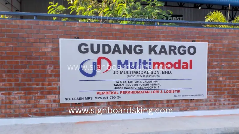 Outdoor Aluminium Composite Signboard JD Multimodal Sdn. Bhd. dipasang pada dinding bata di kawasan gudang.